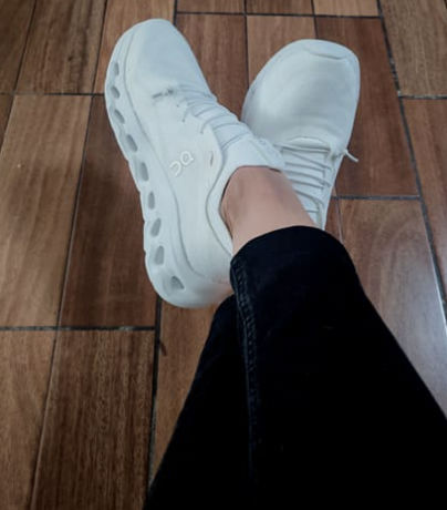 Cliente usando On Cloud X blancos con jeans negros