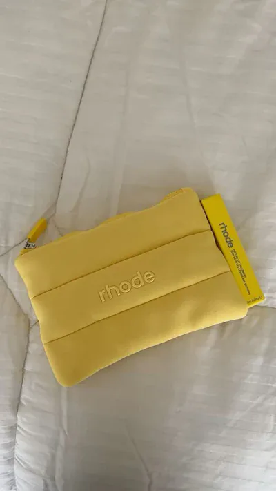 Detalle del logo Rhode en relieve sobre material acolchonado amarillo