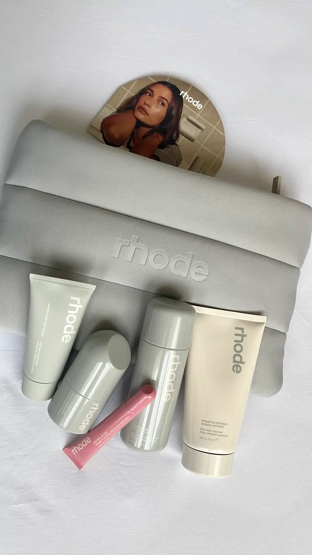 Detalle del logo Rhode en relieve sobre la cosmetiquera gris con skincare rhode