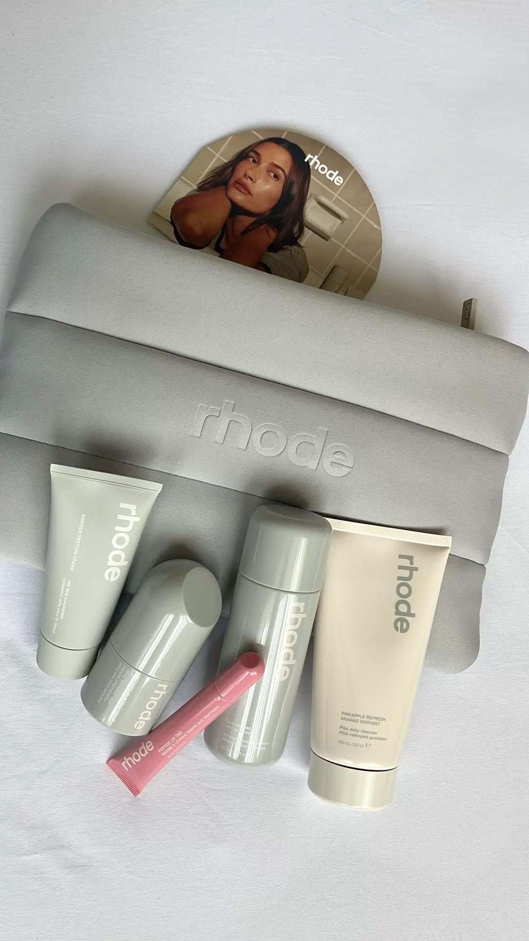 Detalle del logo Rhode en relieve sobre la cosmetiquera gris con skincare rhode