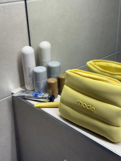 Mujer llevando la cosmetiquera Rhode amarilla