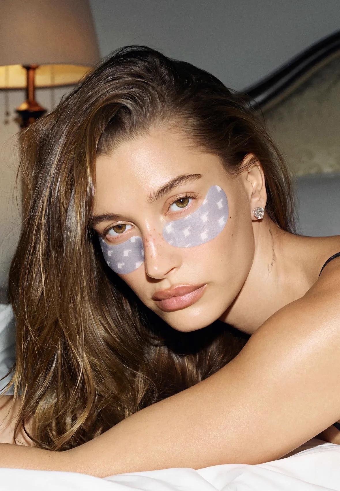 Mujer usando los parches Rhode Peptide Eye Prep