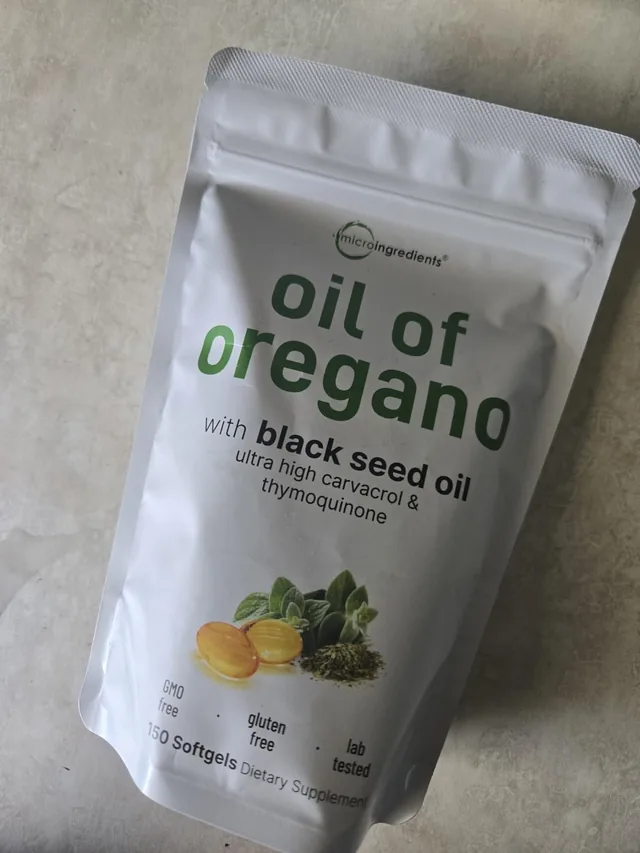 Cápsulas blandas de aceite de orégano en la mano de una clienta