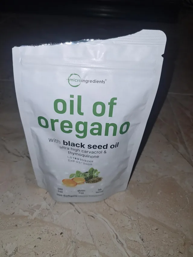 Cliente sosteniendo la bolsa de Oil of Oregano con aceite de semilla negra