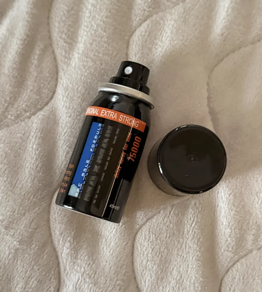 Frasco destapado de Maxman 75000 junto a su tapa